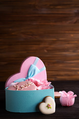 Hearts cookies in box. Festive round blue box with cookies and Rose on dark wooden background, copy space
