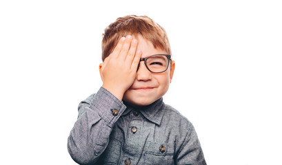 Portrait of little positive boy with eyeglasses smiling at camera, against white background - obrazy, fototapety, plakaty