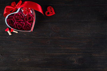Valentines background with red hearts shaped and bouquet rose in gift box on dark wooden background, flat lay copy space