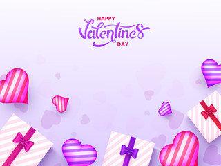 Top view of gift boxes with heart shapes decorated on purple background for Valentine's day celebration poster design.
