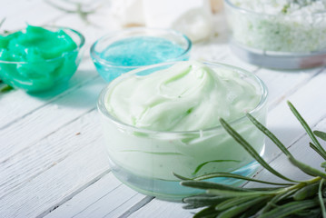 cosmetic cream product samples and raw shea butter, bath salt on white wood table background