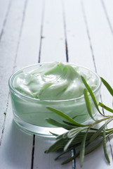 cosmetic cream product samples and lavender leaves on white wooden table background