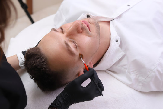 Cleaning the face of a man in a beauty salon.