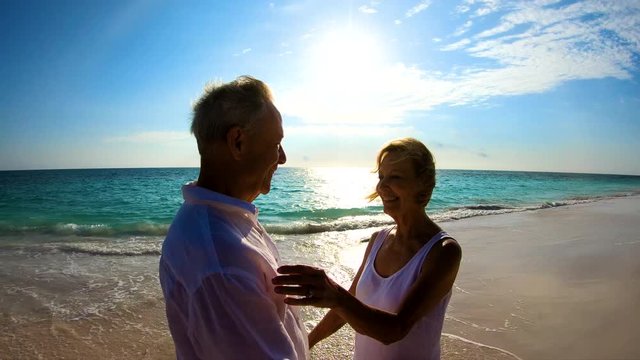 Silhouette of senior couple dancing on beach Bahamas