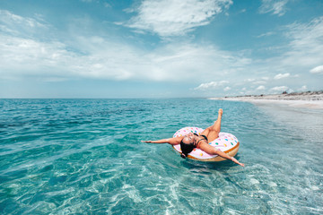 Plus size woman on lilo relaxing on the beach