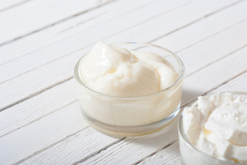 yogurt and creme fraiche on white wooden table background