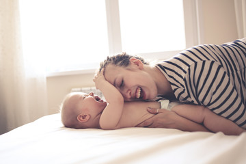 mom kisses and plays with the baby for 6 months