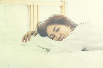 Fototapeta na wymiar Asian woman sleep on white pillow on bed in bedroom in holiday.happy relax time