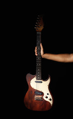 Man holding electric guitar on black background, closeup