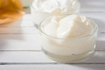 yogurt and creme fraiche on white wooden table background