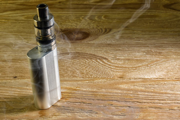 Electronic cigarette shrouded in steam standing on a wooden table