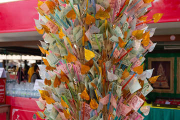 Pile of randomly scattered of thai bhat banknotes on bamboo for donate some money to charity stick