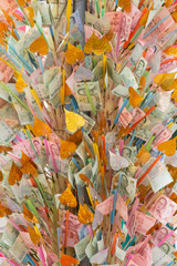 Pile of randomly scattered of thai bhat banknotes on bamboo for donate some money to charity stick