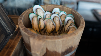 Big raw Mussels on ice  in basket