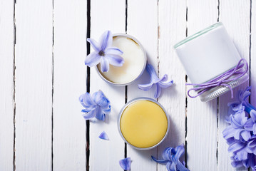 skin care product samples and purple hyacinth flowers on white wooden