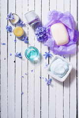 skin care product samples and purple hyacinth flowers on white wooden