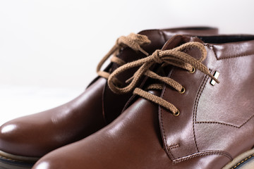 Men's classic brown leather shoes on white background. Close up