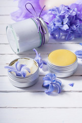 skin care product samples and purple hyacinth flowers on white wooden