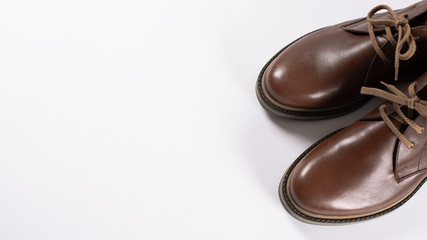 Male fashion. Brown leather shoes on white background. Copy space. Top view. For banner