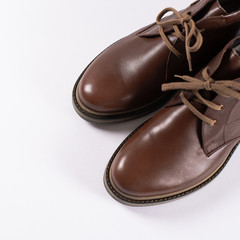 Beautiful brown luxury and casual leather male shoes on white background. Fashion accessories. Top view. Copy space