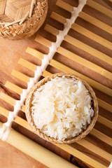 Asian Thai food Glutinous or sticky rice in bamboo wicker on wooden background with copy space
