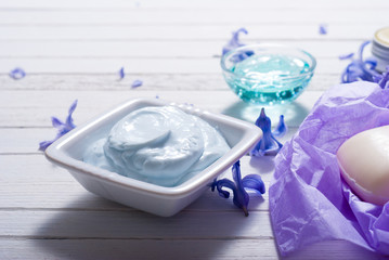 skin care product samples and purple hyacinth flowers on white wooden