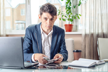 Naklejka premium Businessman sitting in the office takes a bribe with his hands counting the money. Concept of corruption and bribery
