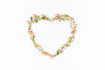 Heart of pink roses on white background. Flat lay, top view. Floral background. Valentine's background.
