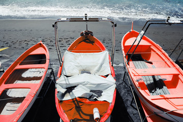 Fototapeta na wymiar colorful fishing wooden boat moored on the beach - coral color