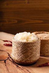 Asian Thai food Glutinous or sticky rice in bamboo wicker on wooden background with copy space