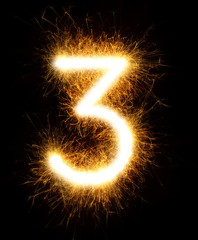 Number 3 drawn with spaklers on a black background