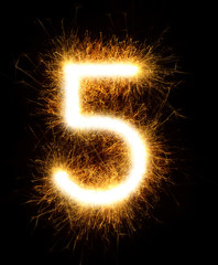 Number 5 drawn with spaklers on a black background