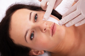 Therapist Waxing Woman's Face