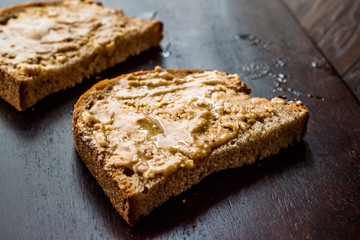 Creamy Peanut Butter with Bread on Wooden Board.