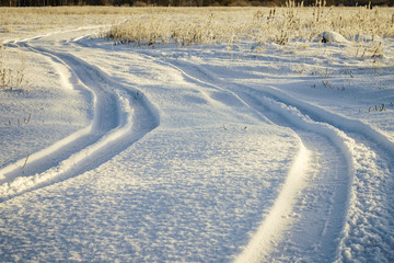 Car tire tracks in fresh snow.