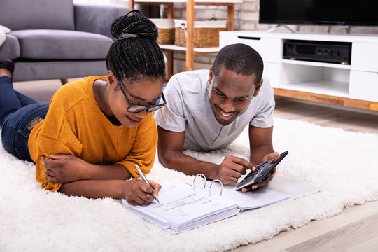 African Couple Calculating Invoice With Calculator