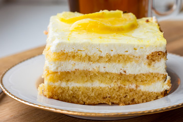 a piece of sponge cake with light curd layer and lemon closeup