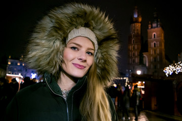 portrait of a young woman on the market square in cracow with the St. Mary's church in the...