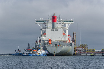 Naklejka premium LNG TANKER - Ship and tugs are maneuvering at the gas terminal in Swinoujscie