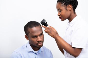 Doctor Examining Man's Hair With Dermatoscope