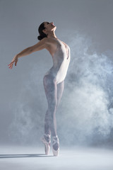 Elegant woman female girl ballerina dancer in beige body pointe shoes dancing, making performance...