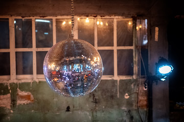 Mirror ball under the ceiling on the background of old walls and Windows.