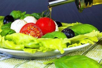 Olive oil is an important part of refreshing summer salads: Salad Caprese, a traditional and Mediterranean salad.