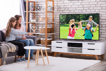 Mother And Daughter Watching Television In Living Room