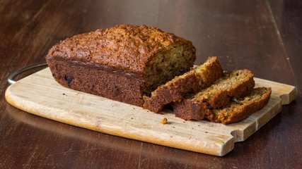 freshly baked banana bread sliced on wood board 