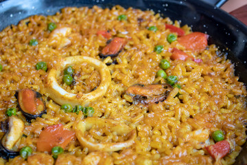 Fresh Spanish paella with rice and seafood in frying pan closeup