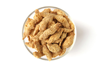 Raw soy chunks in glass bowl isolated on white background. Dry soya pieces meat used in vegetarian and vegan food. top view
