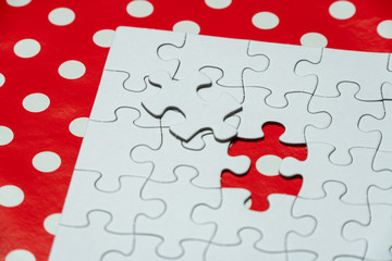 white, empty puzzle with missing element on a red background