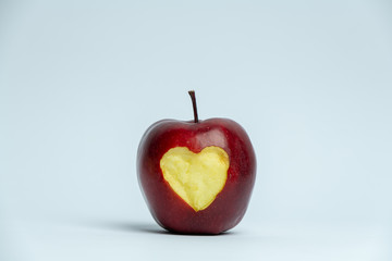 red apple with a cut heart shape on a white background
