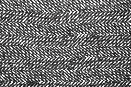 Herringbone fabric, texture background. Black and white tweed pattern, weaving, textile material. 